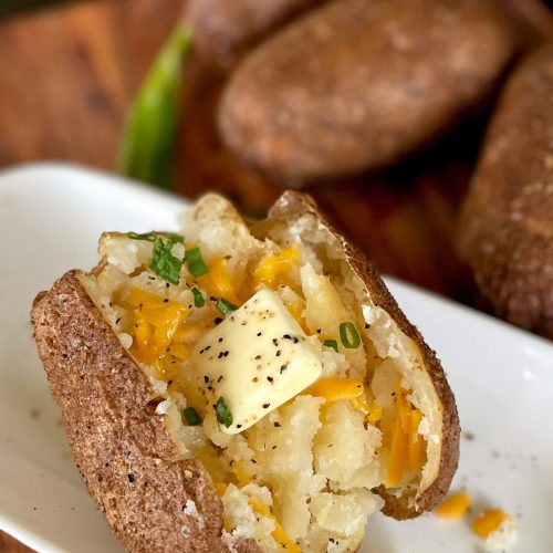 smoked baked potatoes on a plate with butter