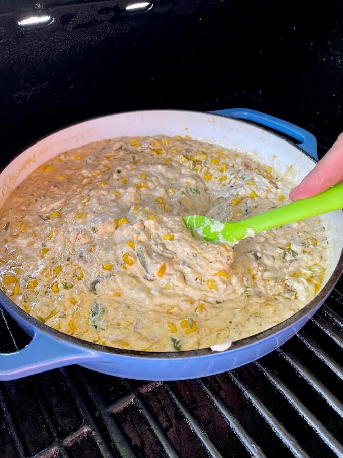 making smoked street corn dip in a cast iron skillet