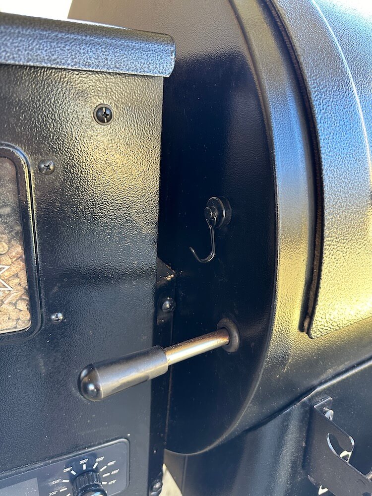 magnetic hook covering the thermometer port on a pit boss pellet grill