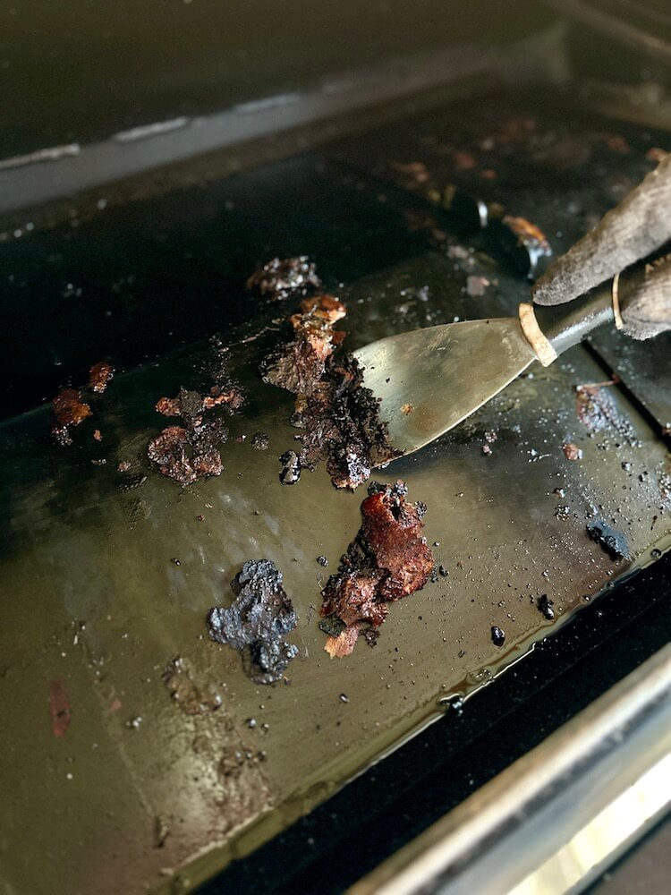 scraping the heat deflector in a pellet grill