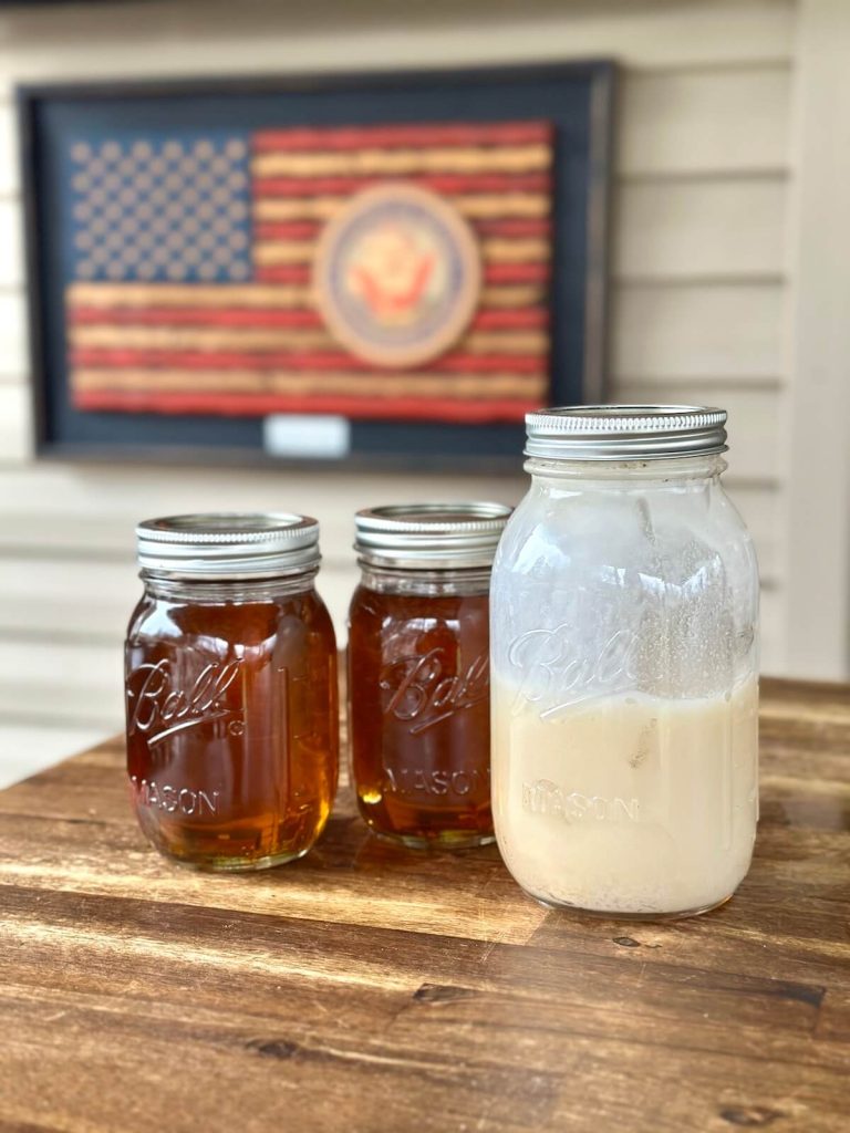 three jars of beef tallow, one that is solid and two jars of liquid brisket tallow