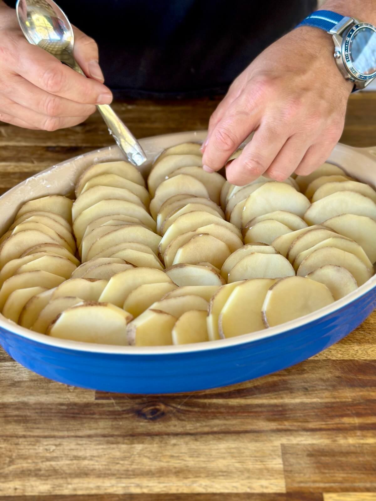 sliced potatoes stacked in a casserole dish