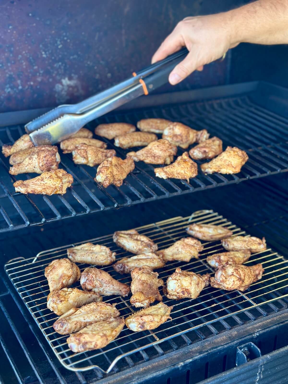 flipping chicken wings with tongs