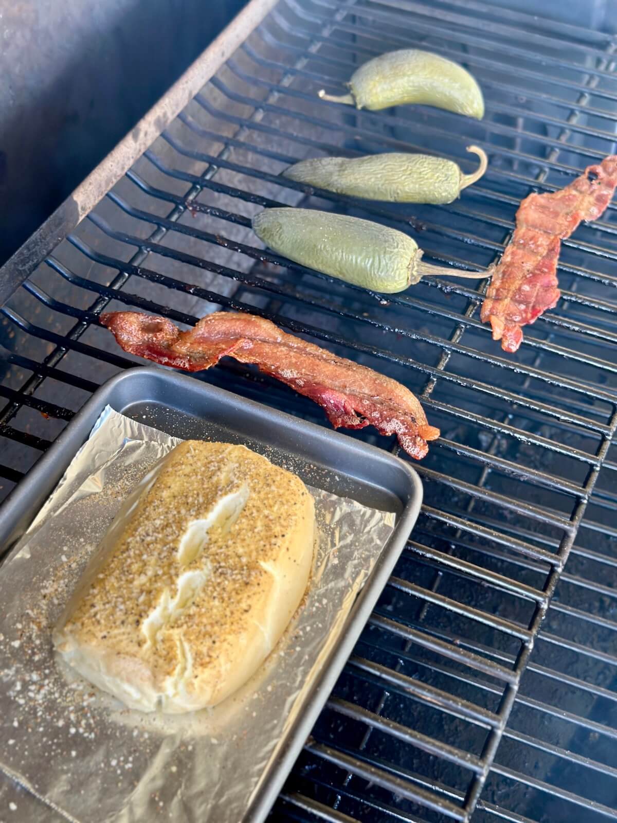 smoking cream cheese, whole jalapeños, and sliced bacon on a pellet grill