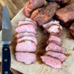 smoked pork tasso sliced on a cutting board