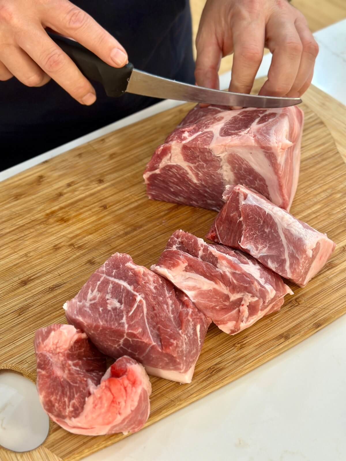 cutting a pork butt into chunks