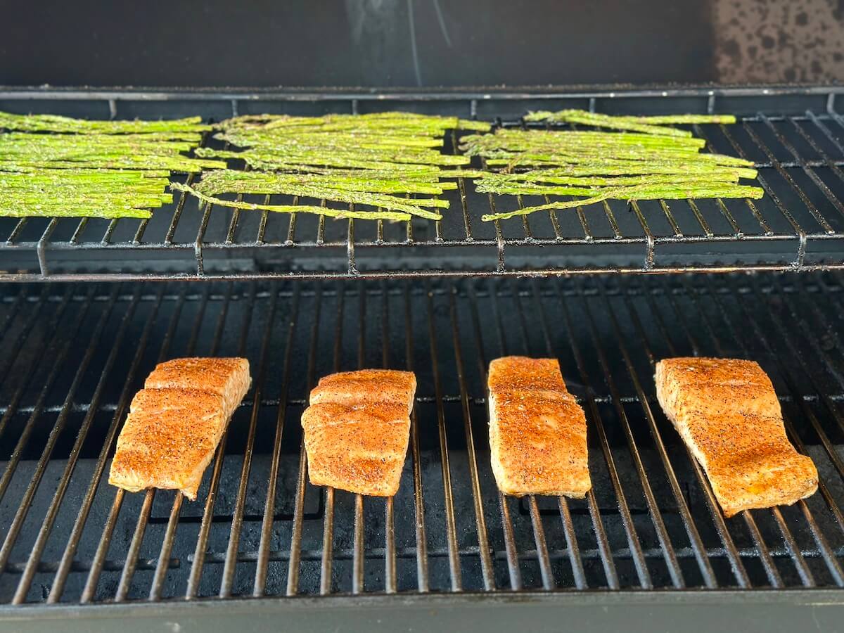 salmon filets and asparagus cooking on a Traeger pellet grill