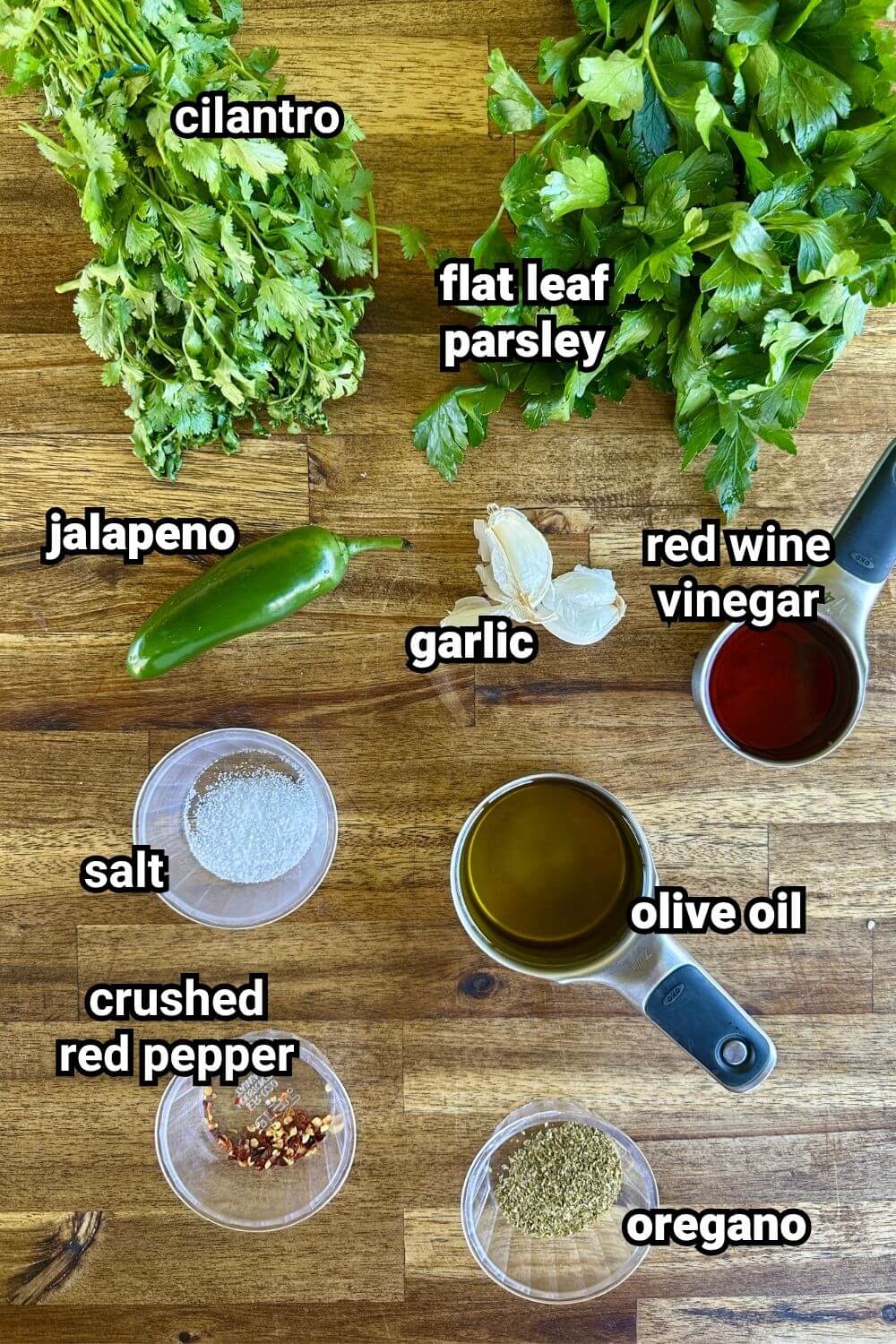 ingredients for chimichurri sauce including fresh herbs, olive oil, and vinegar