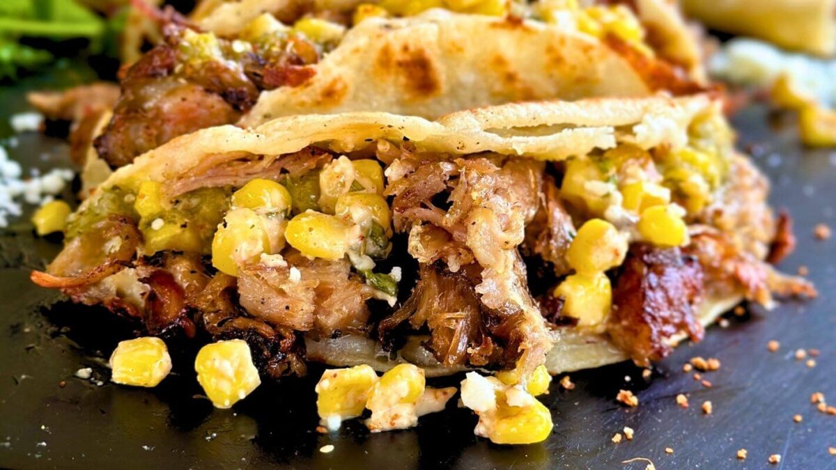 smoked pulled pork tacos on corn tortillas with salsa verde and Mexican street corn