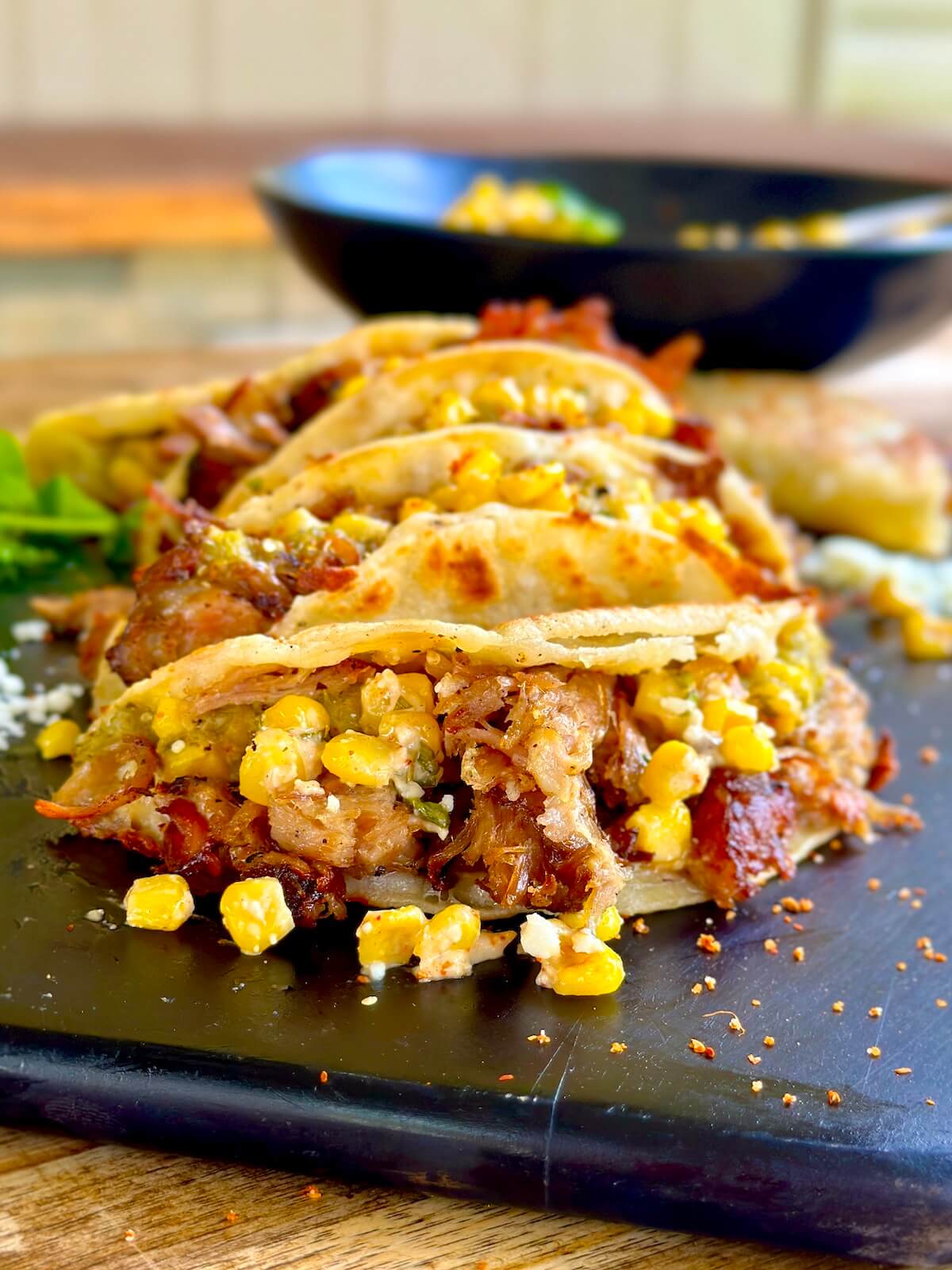 pulled pork tacos with Mexican street corn and tomatillo salsa on corn tortillas