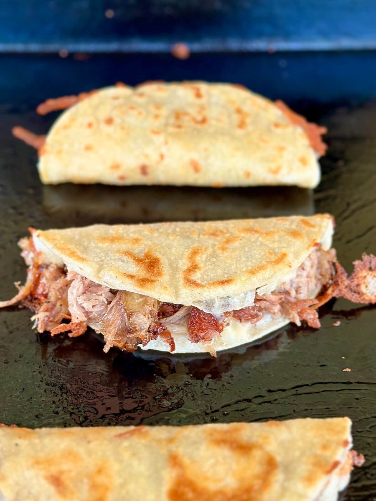 pulled pork tacos cooking on a griddle