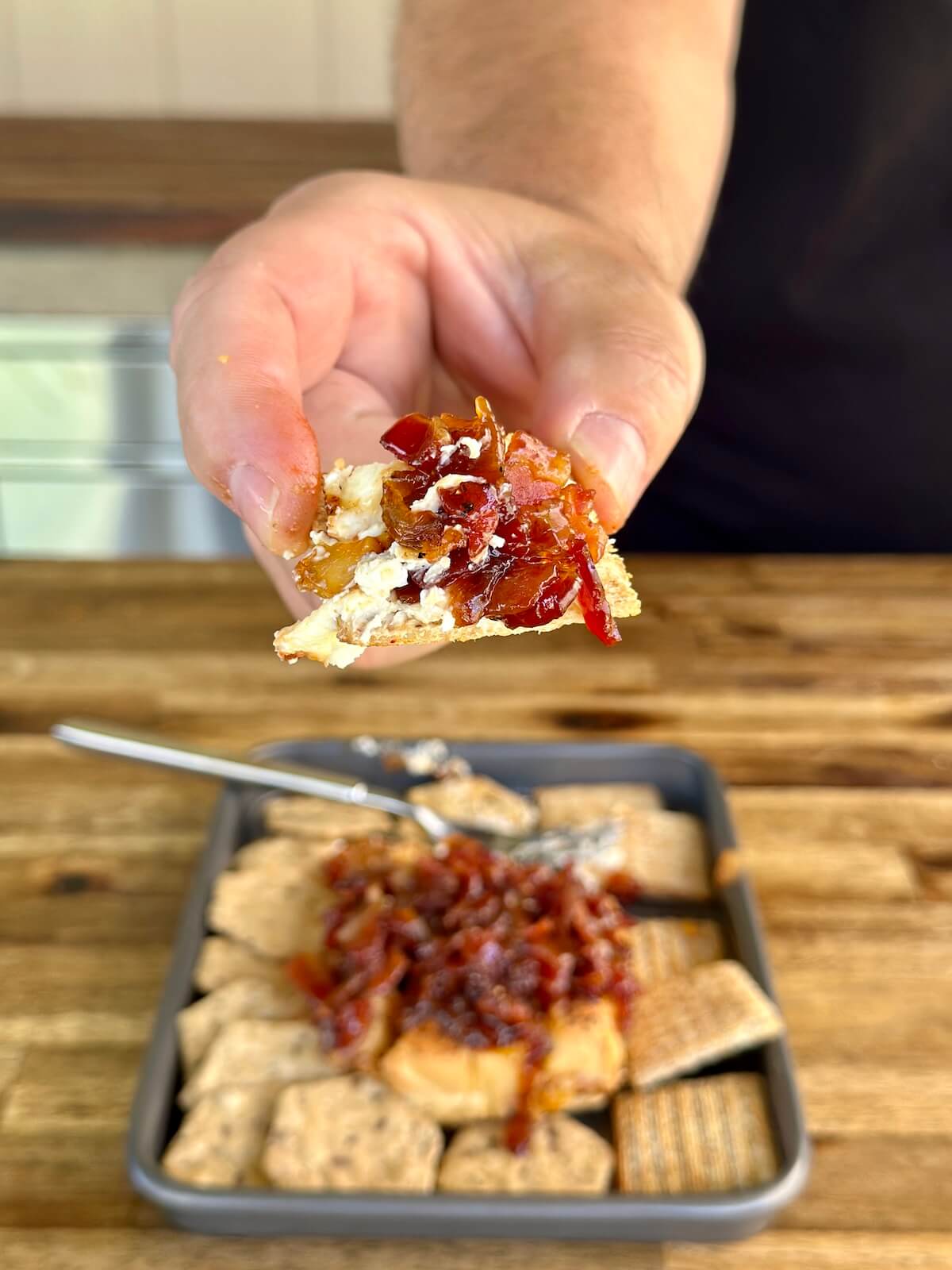 smoked cream cheese on a cracker with a bacon onion jam topping
