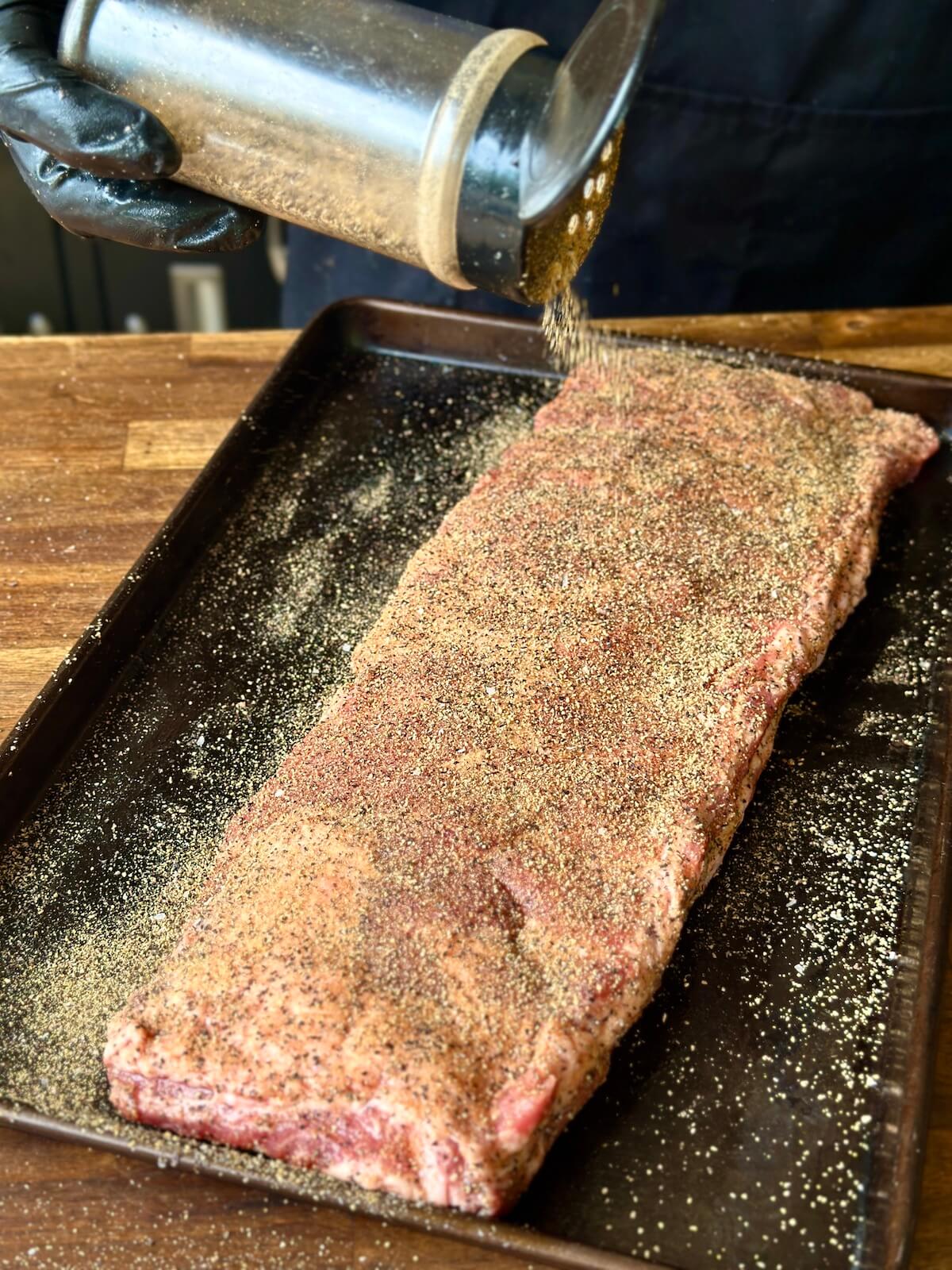 seasoning pork spare ribs with a Texas style rub