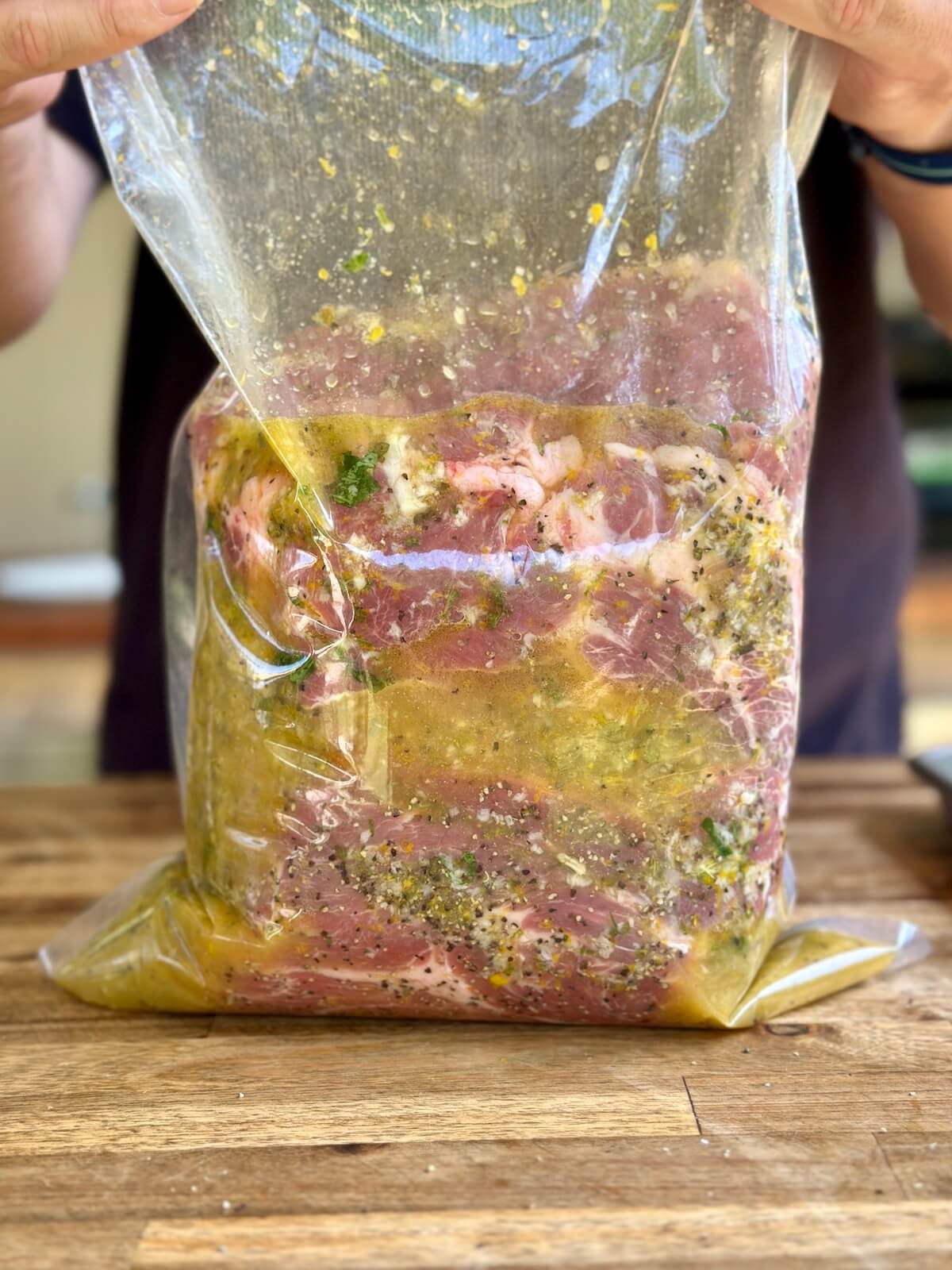 marinating a pork butt in mojo marinade in a bag