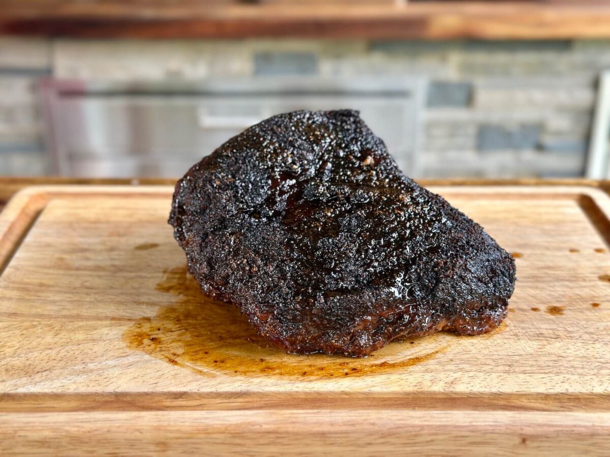 the point portion of a brisket smoked and resting on a cutting board