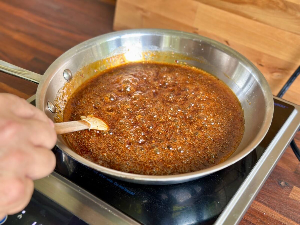 sticky Asian sauce reducing in a skillet
