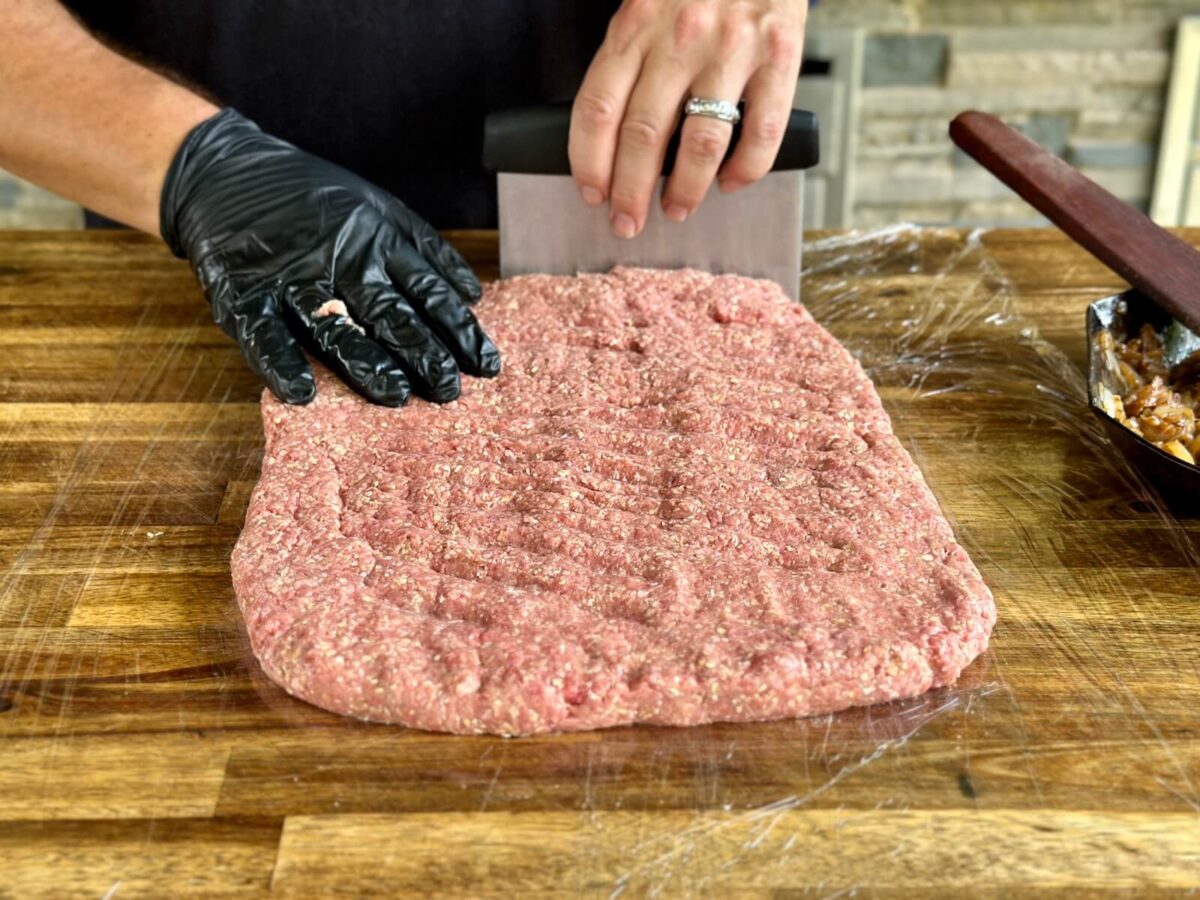 patting meatloaf ground beef mixture out into a thin rectangle