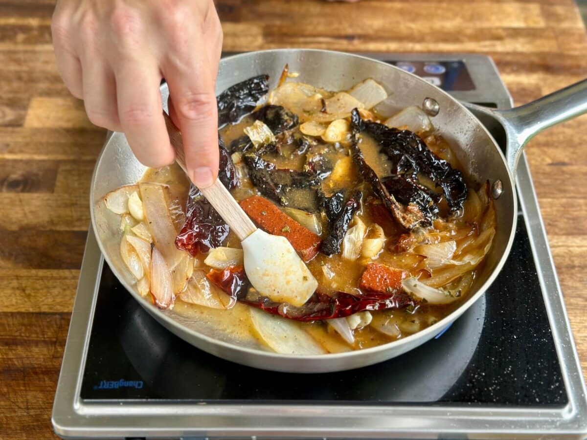 cooking peppers, onions, and Mexican spices in a skillet