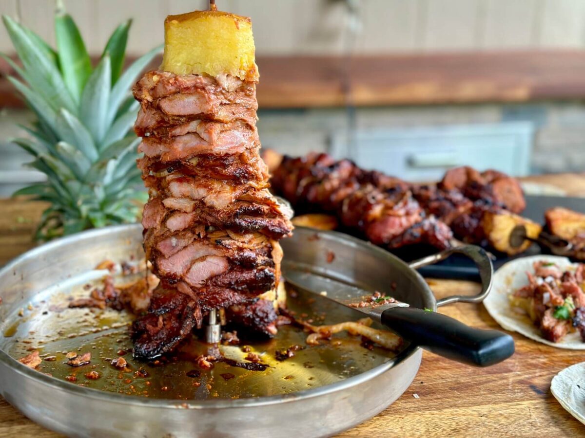 a vertical skewer of al pastor with pineapple