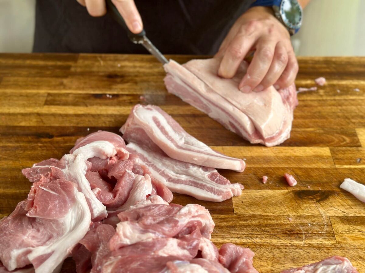 slicing a pork butt into thin slices