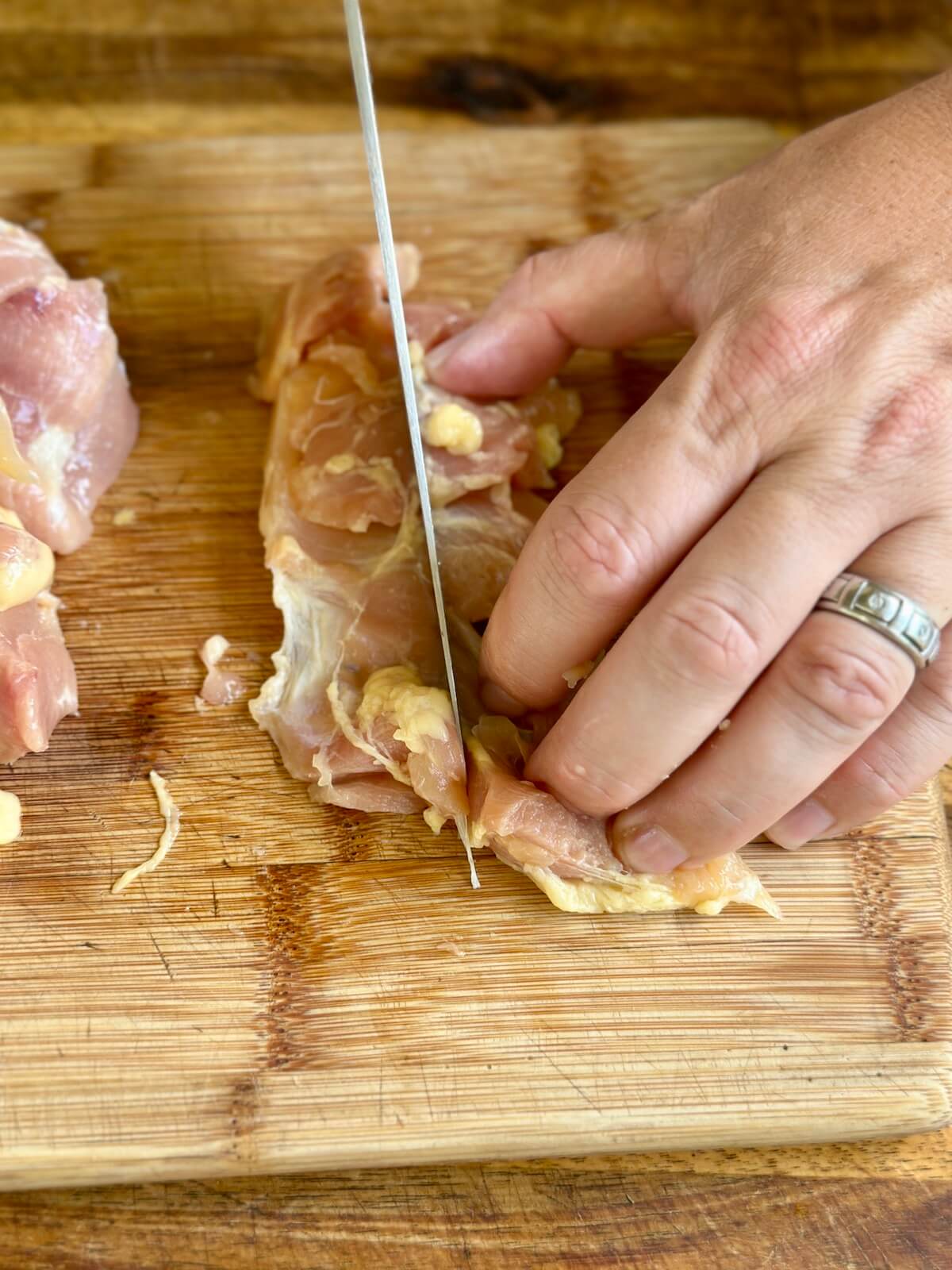 cutting boneless skinless chicken thighs in half lengthwise into two long strips