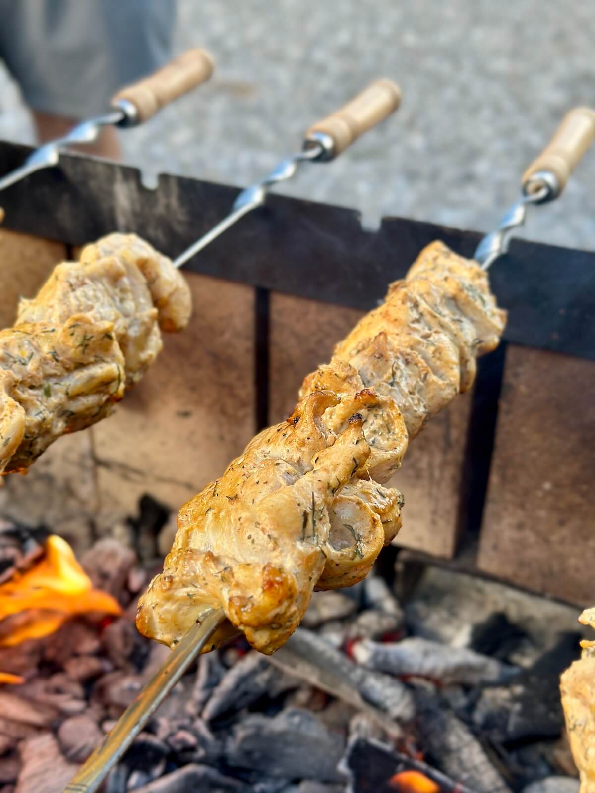 grilling Greek chicken skewers over an open flame