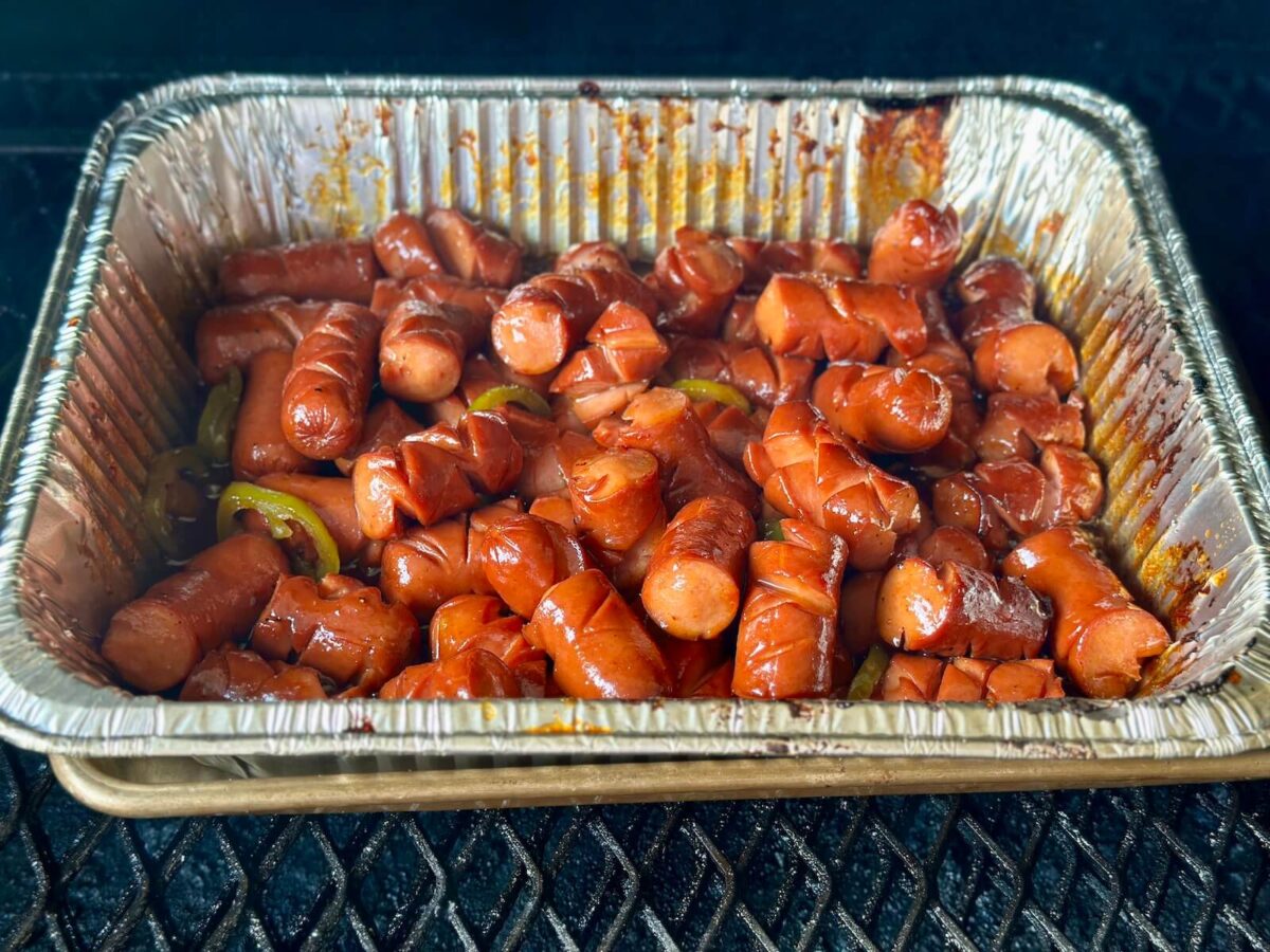 making smoked hot dog burnt ends in a foil pan on a grill