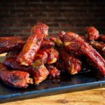 smoked party ribs with barbecue sauce on a cutting board