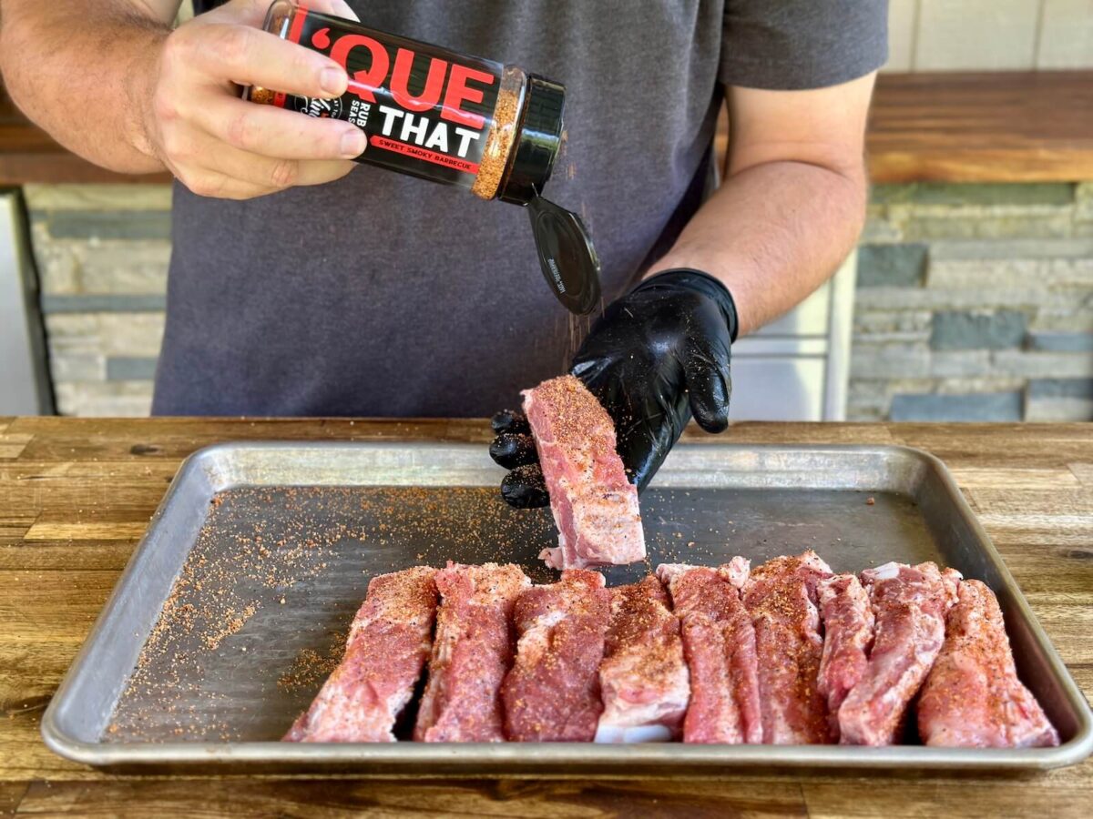 seasoning individual pork ribs with Que That seasoning
