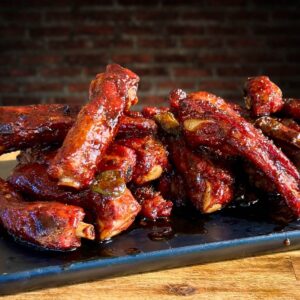 smoked party ribs with barbecue sauce on a cutting board