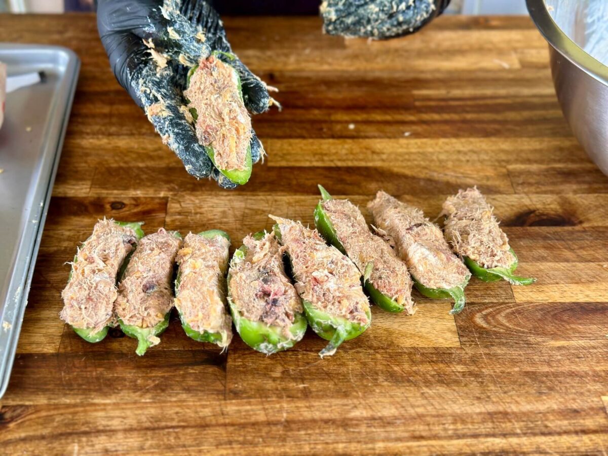 halved jalapenos that have been stuffed with pulled pork and cream cheese