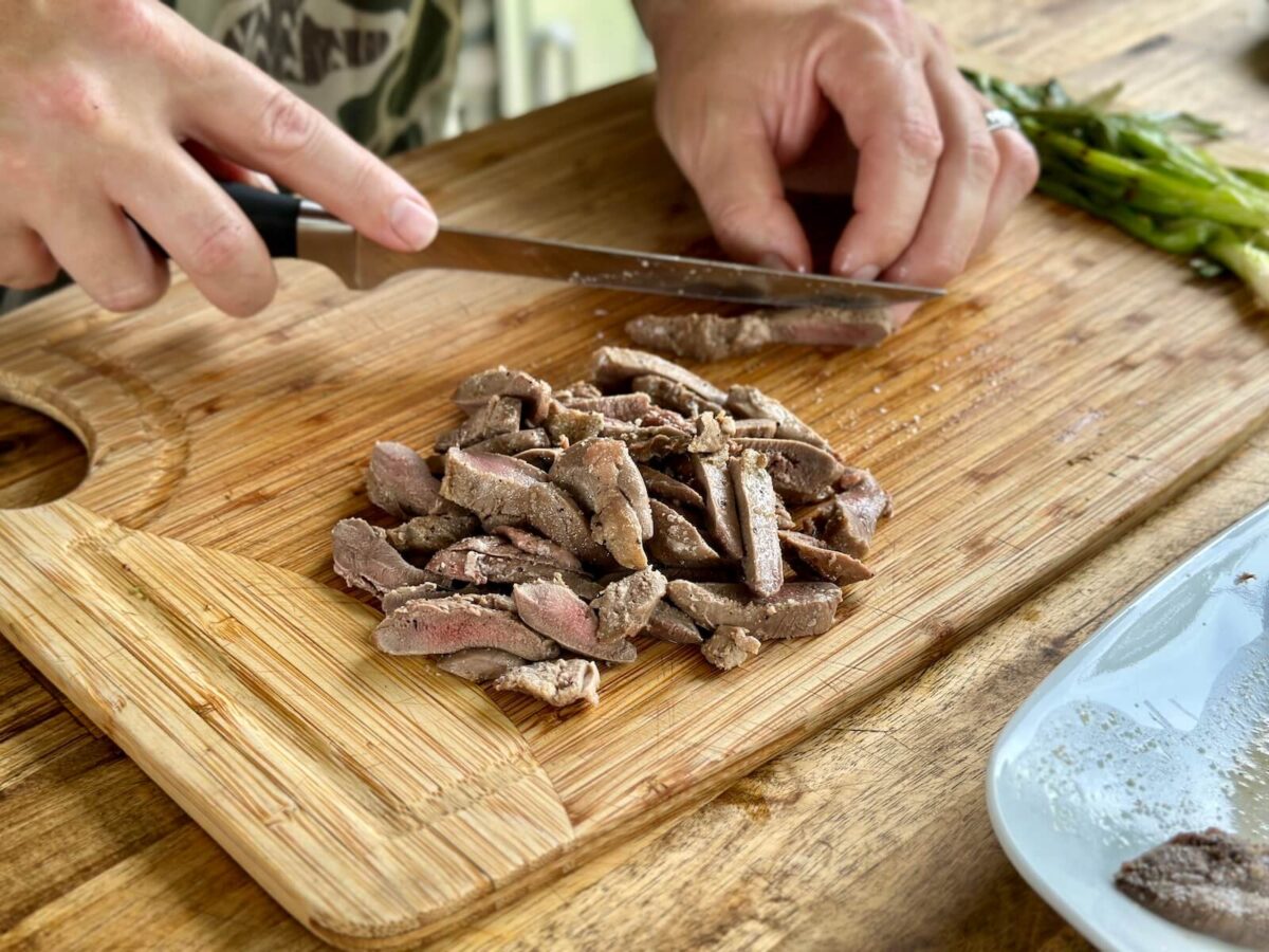 cutting seared dove breasts into thin strips
