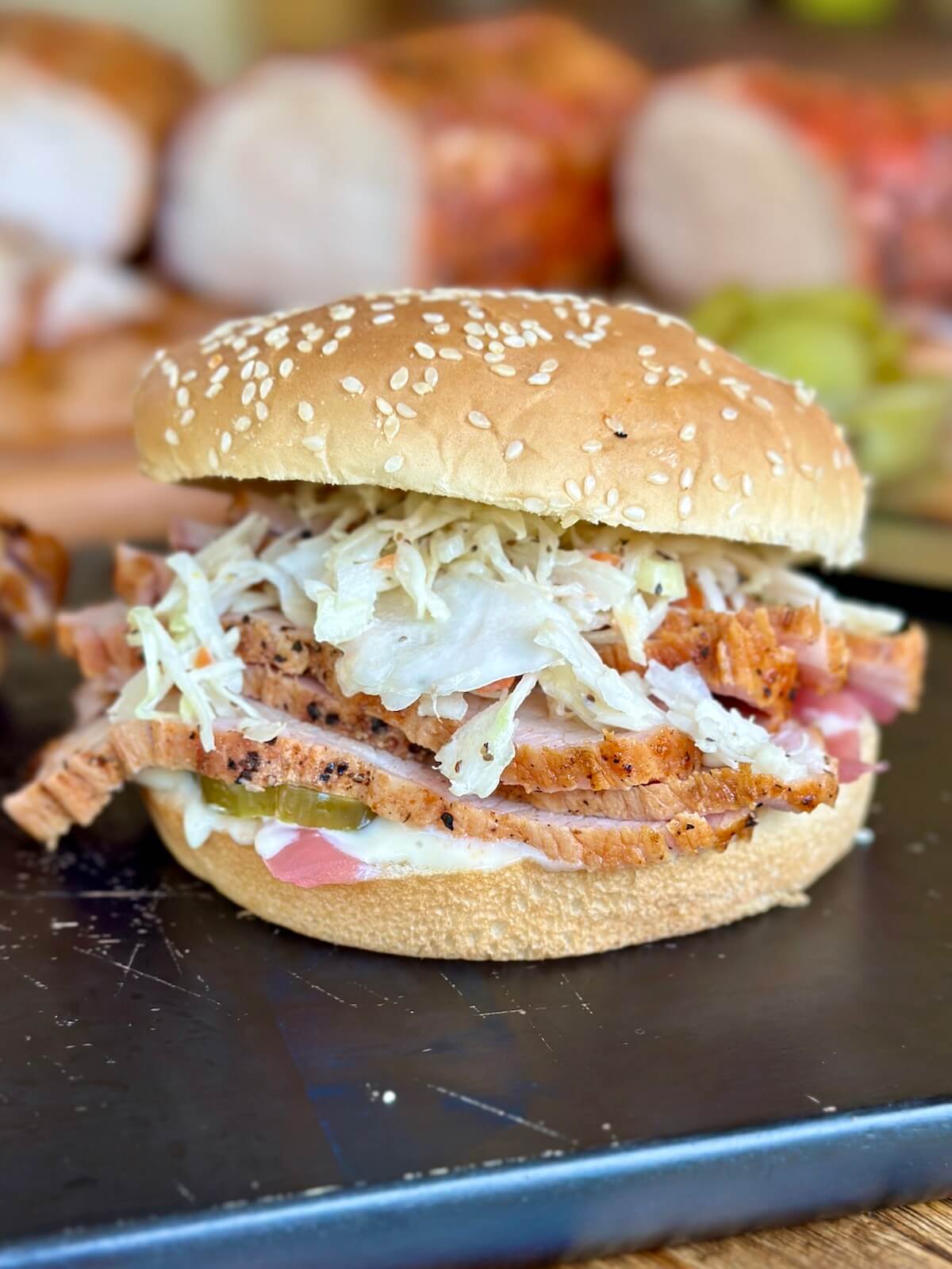 smoked pork loin sandwich with apple coleslaw and pickled red onions