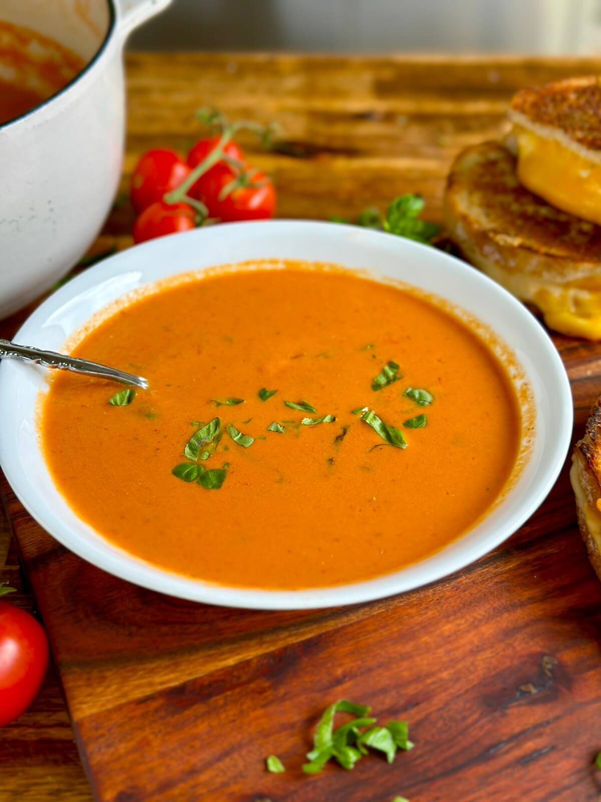 smoked tomato soup in a bowl with torn pieces of basil