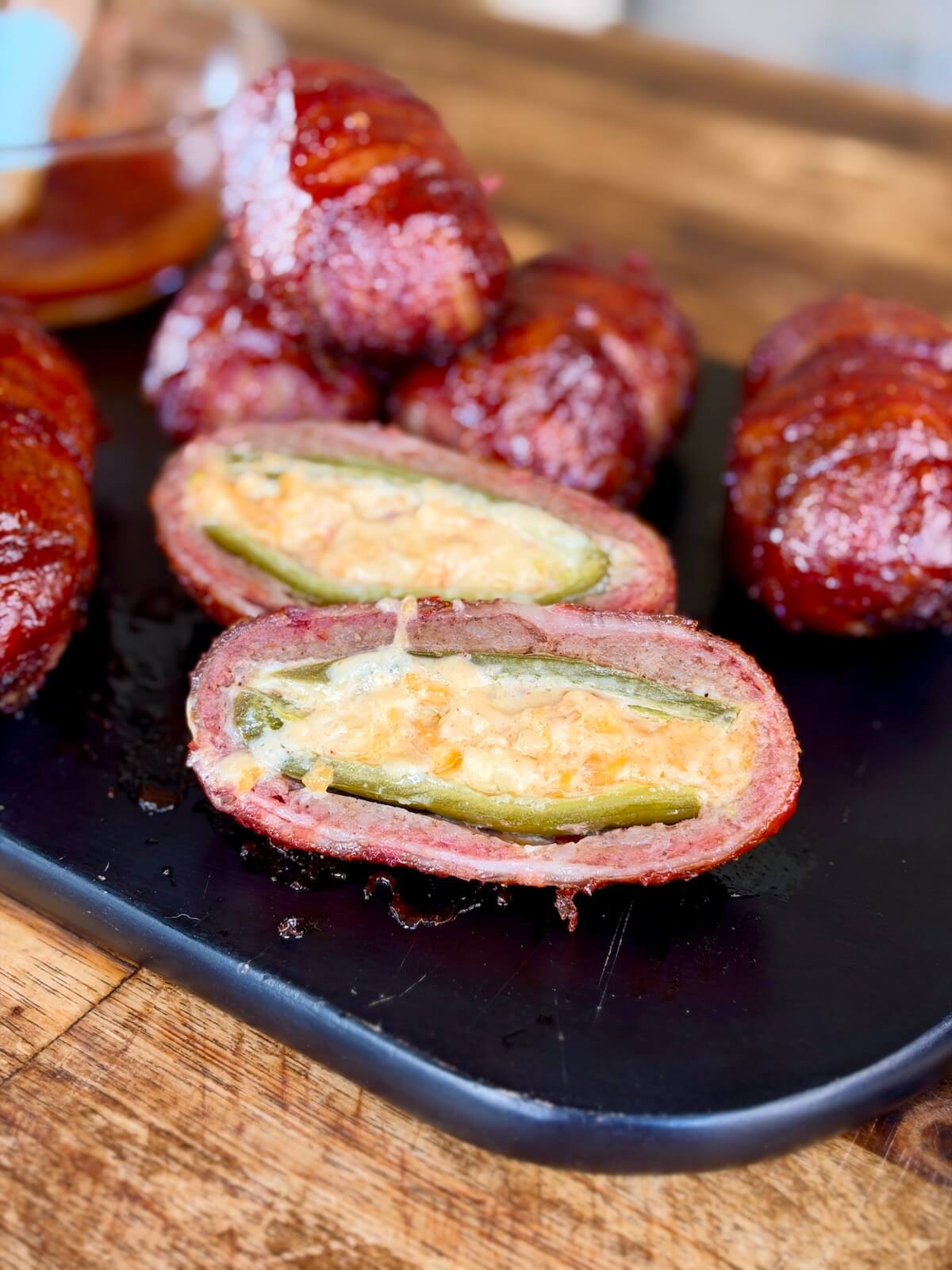 cheese-stuffed armadillo eggs wrapped in bacon and glazed in bbq sauce